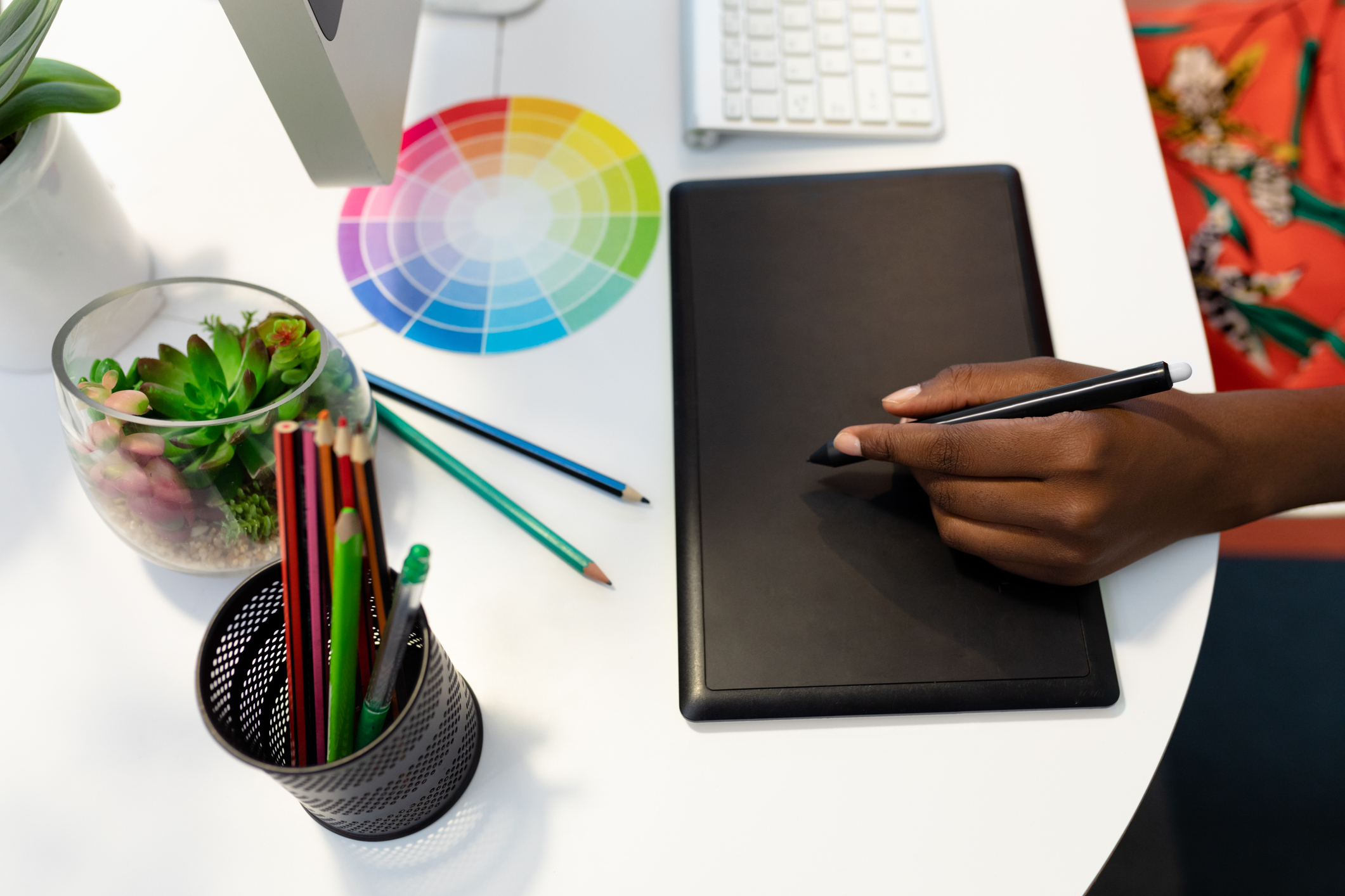 Female Graphic designer using graphic tablet at desk in office